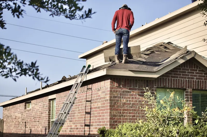 Professional roofer working on a residential roof in Holmby Hills